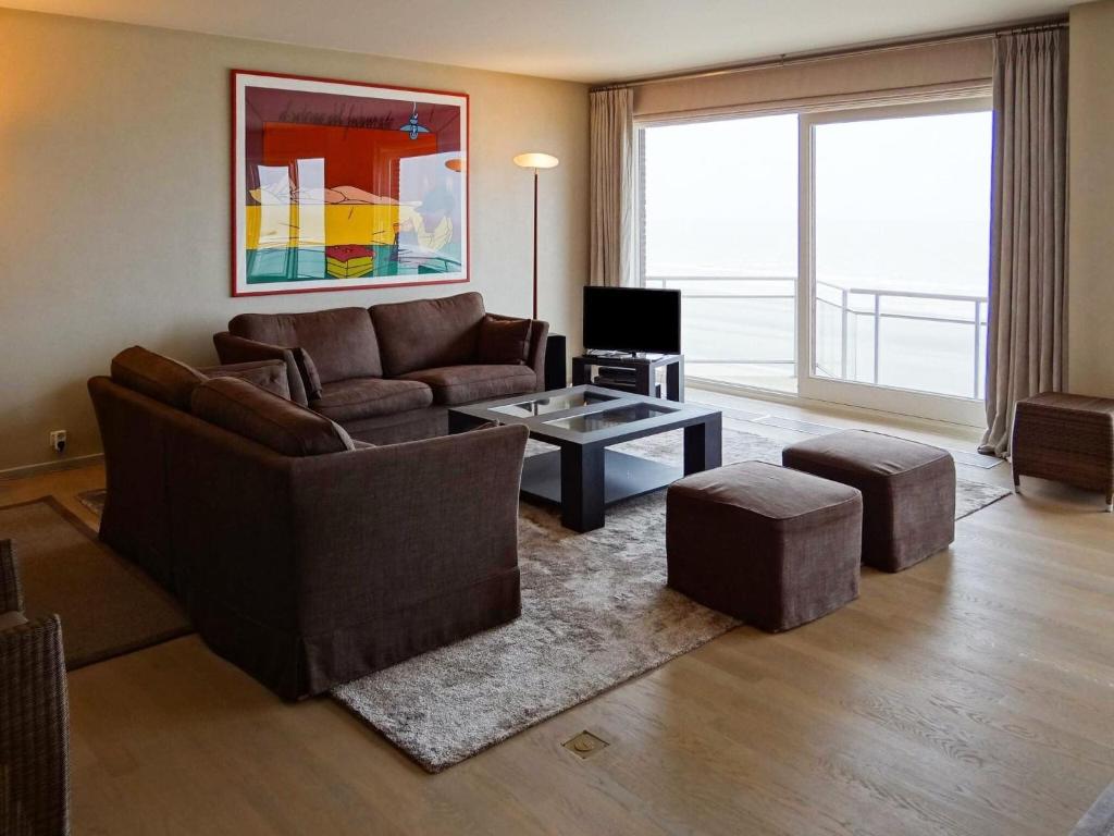 sala de estar con sofá y mesa en Seawind 503 with frontal sea view, en Nieuwpoort