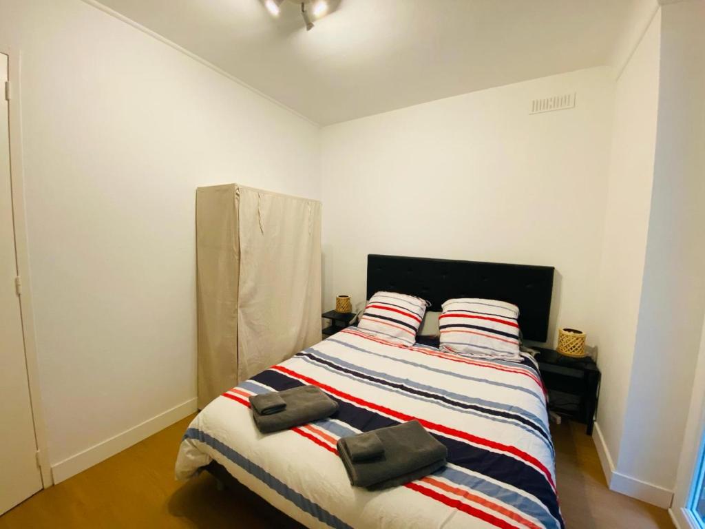 una camera con un letto con due cuscini sopra di Appartement Confortable - Trignac Centre Ville a Trignac