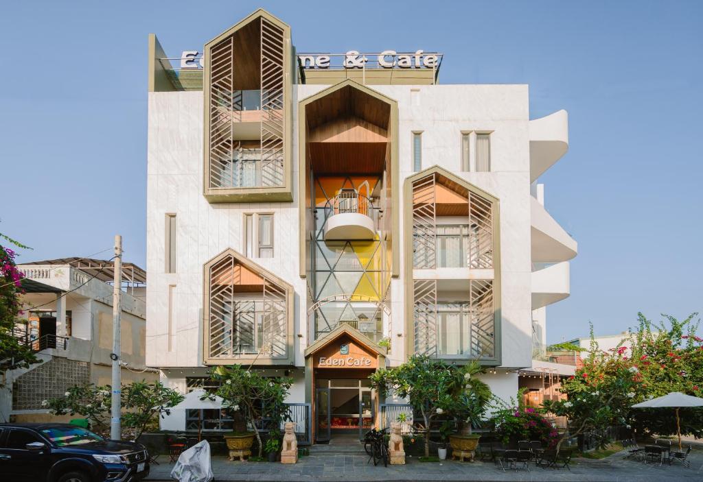 a white building with windows and a sign on it at Eden Home&Cafe in Quy Nhon