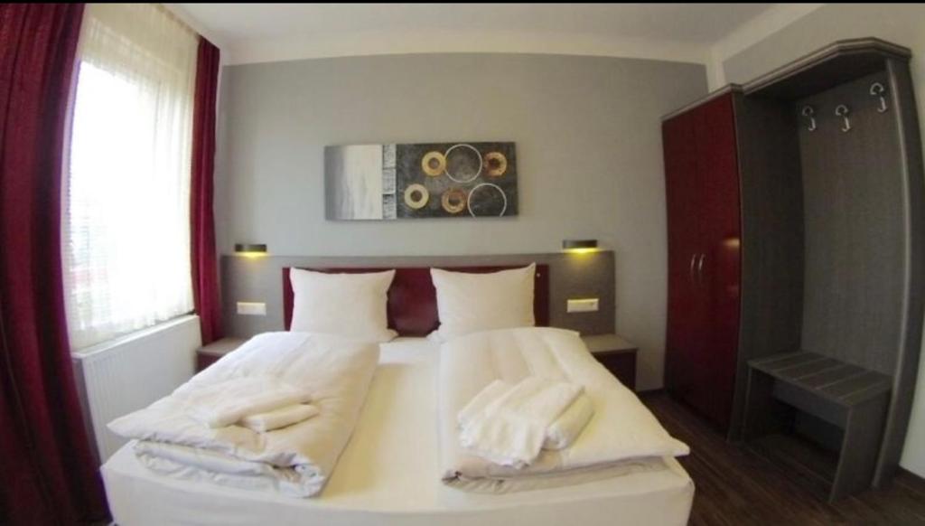 a bedroom with a bed with two towels on it at Ariston Hotel in Sindelfingen
