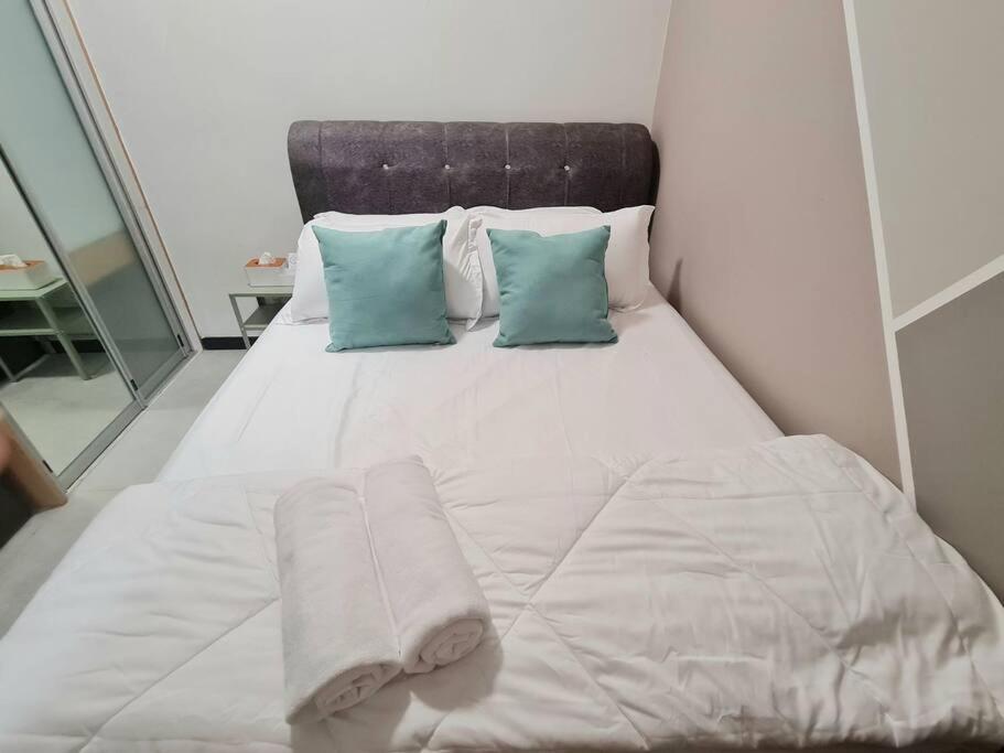 a white bed with two pillows and two towels on it at Tiny Studio Suite Near Gleneagles 10 mins to KLCC in Kuala Lumpur