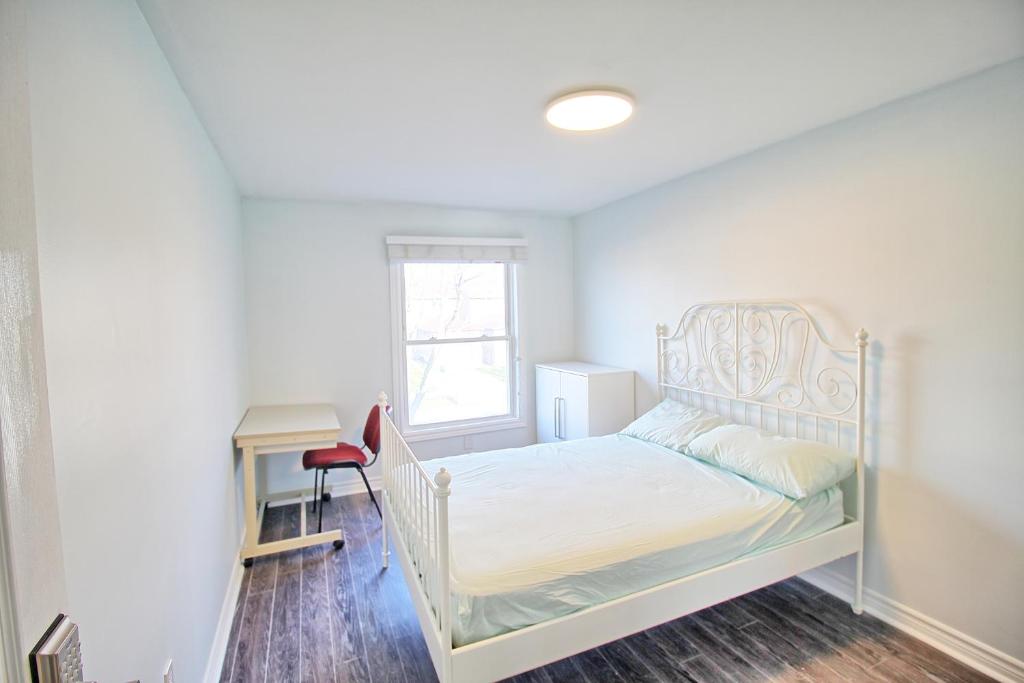 1 dormitorio con cama blanca y escritorio en A Quiet And Bright Room, en Vaughan