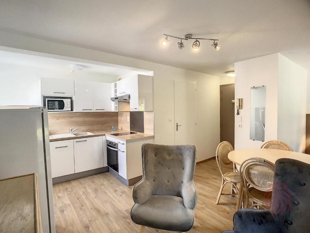 une cuisine et une salle à manger avec une table et des chaises dans l'établissement Studio cosy à 50m des Thermes de Lamalou-les-Bains avec terrasse, wifi et animaux acceptés - FR-1-451-46, à Lamalou-les-Bains