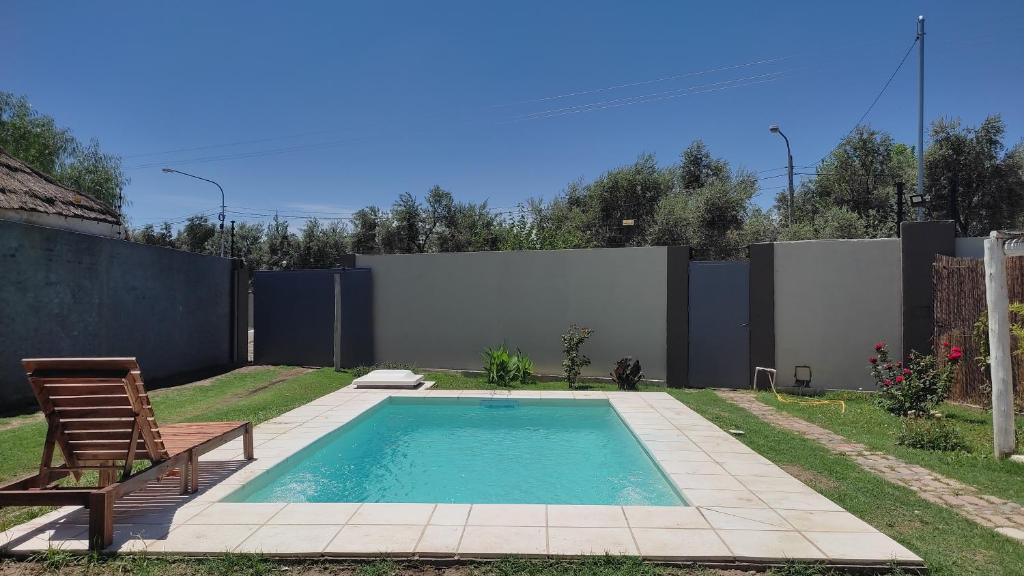 una piscina en un patio trasero con un banco y una silla en Llevarte a vivir en San Rafael