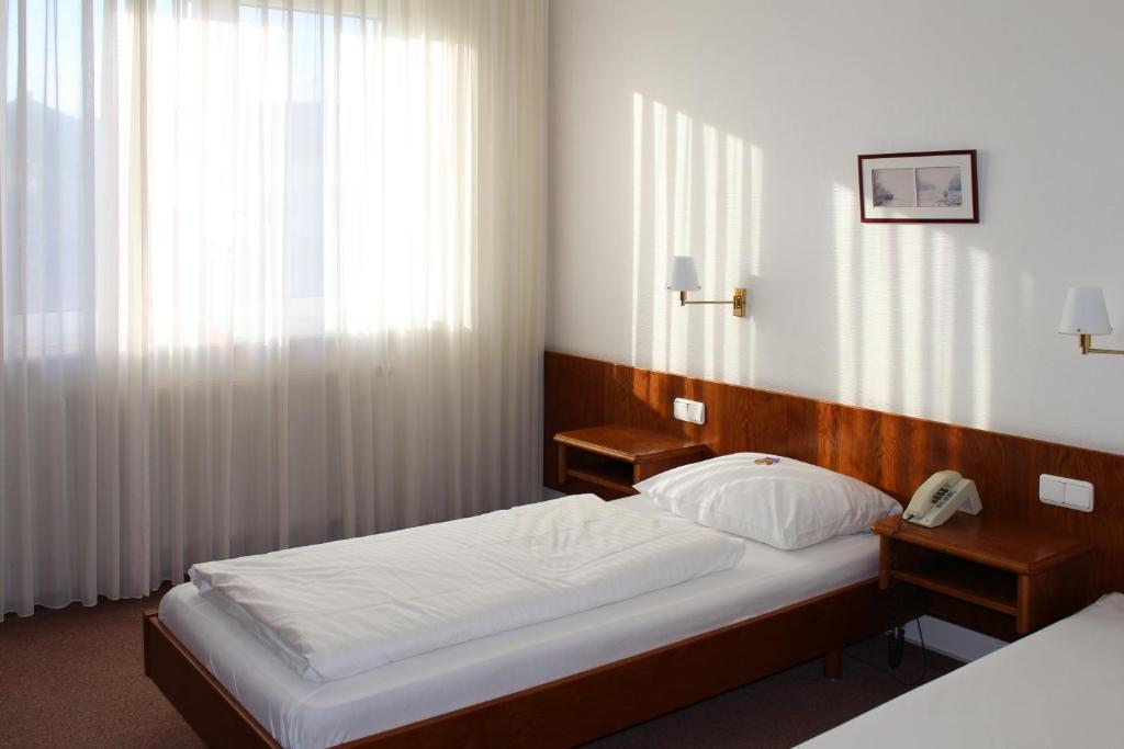 a bedroom with a bed and a telephone in it at Hotel Post in Rosbach vor der Höhe