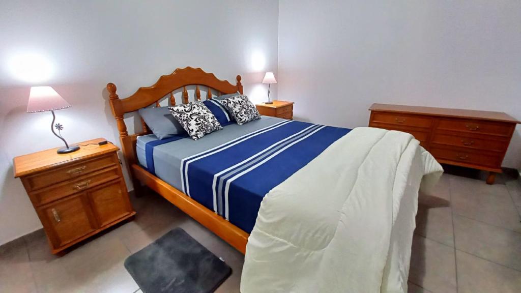 a bedroom with a bed with a blue and white comforter at Sueños Del Pilar II in Godoy Cruz