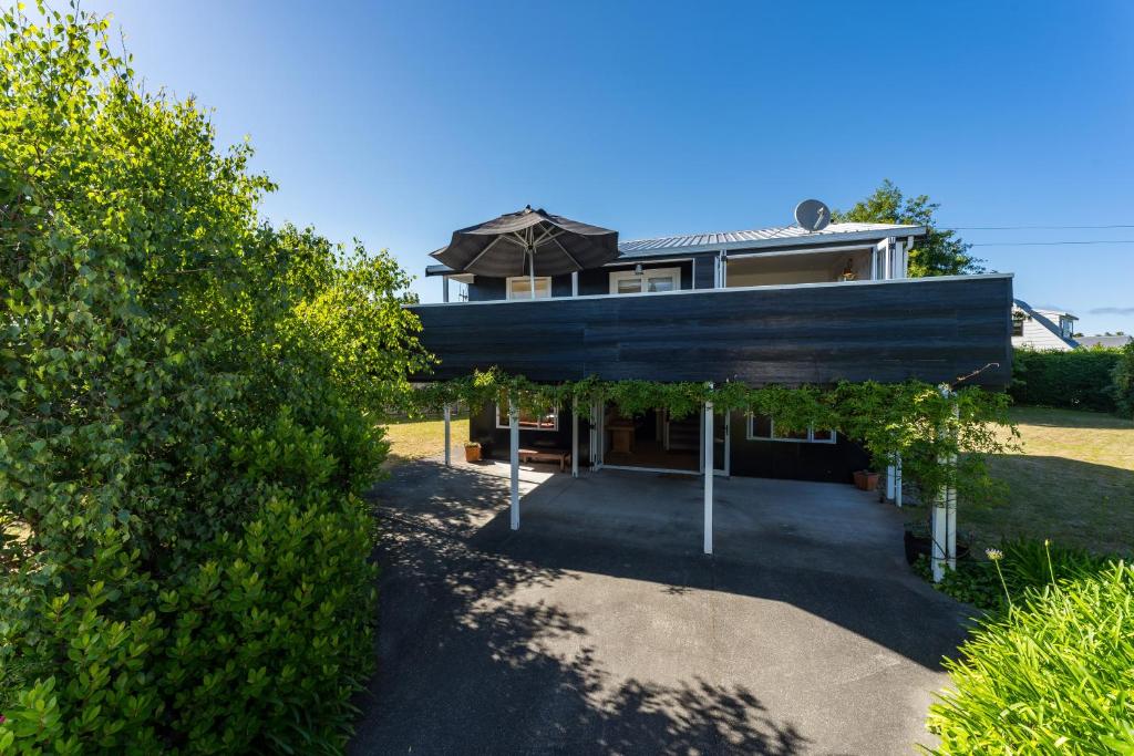 a house with an umbrella in front of it at Close to the Lake in Taupo
