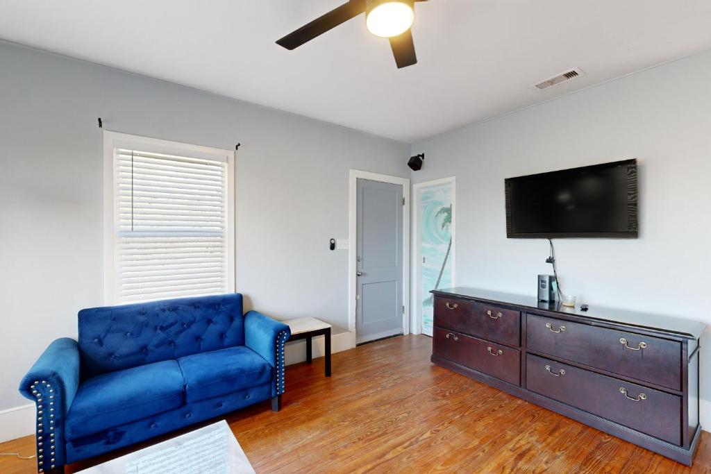 een woonkamer met een blauwe bank en een flatscreen-tv bij The Sandpiper in Angleton