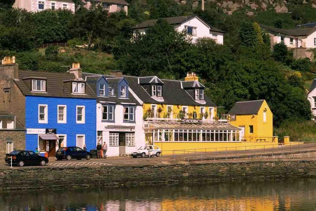 um grupo de casas ao lado de uma massa de água em Penlea ~ 1 bedroom Flat with Harbour view em Tarbert