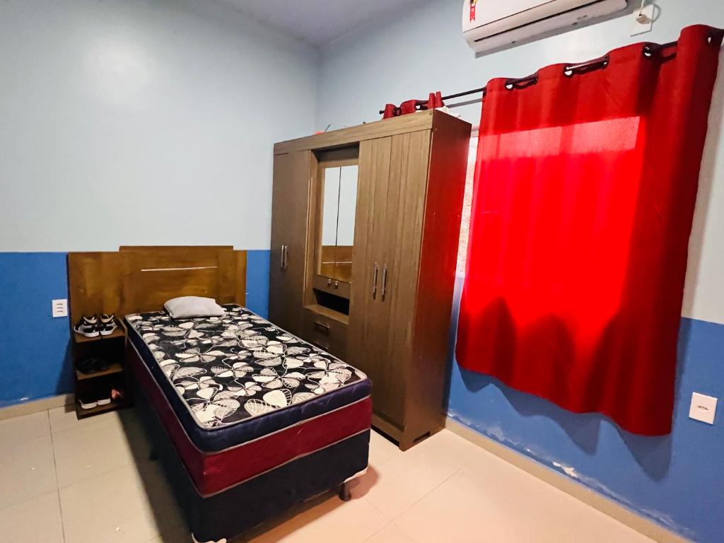 um pequeno quarto com uma cama e um armário em Suíte privativa em Parintins