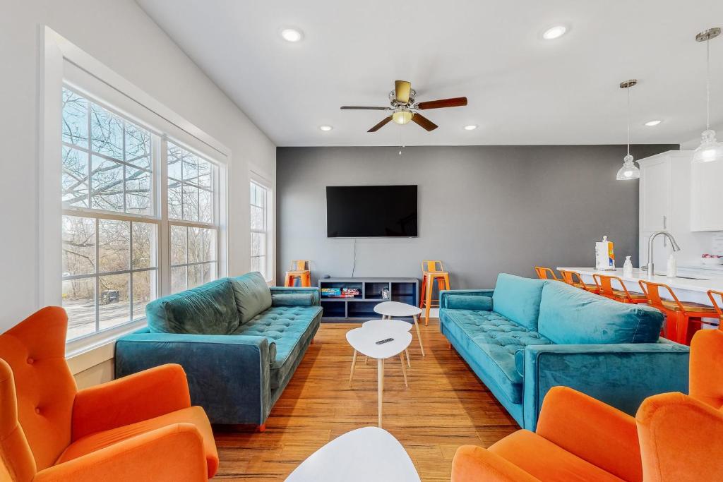a living room with blue couches and orange chairs at Blooming Fields in Nashville