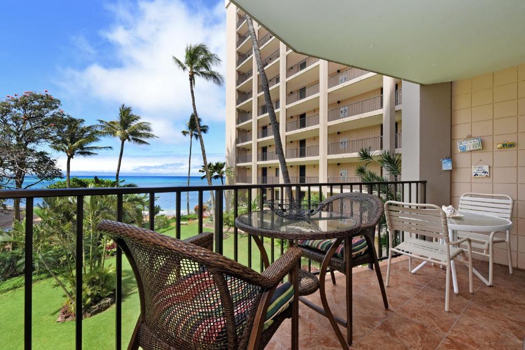 a balcony with a table and chairs and a view of the ocean at Valley Isle 302 in Kahana