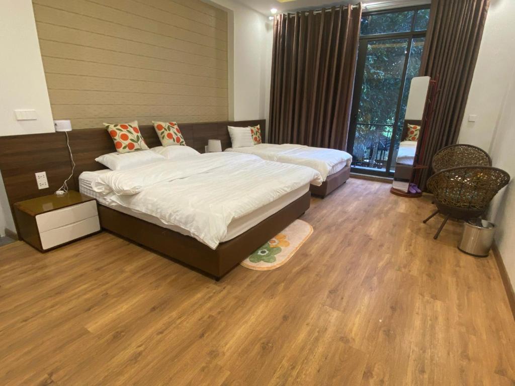 um quarto com duas camas e piso de madeira em Hà Thành Villa em Hanói