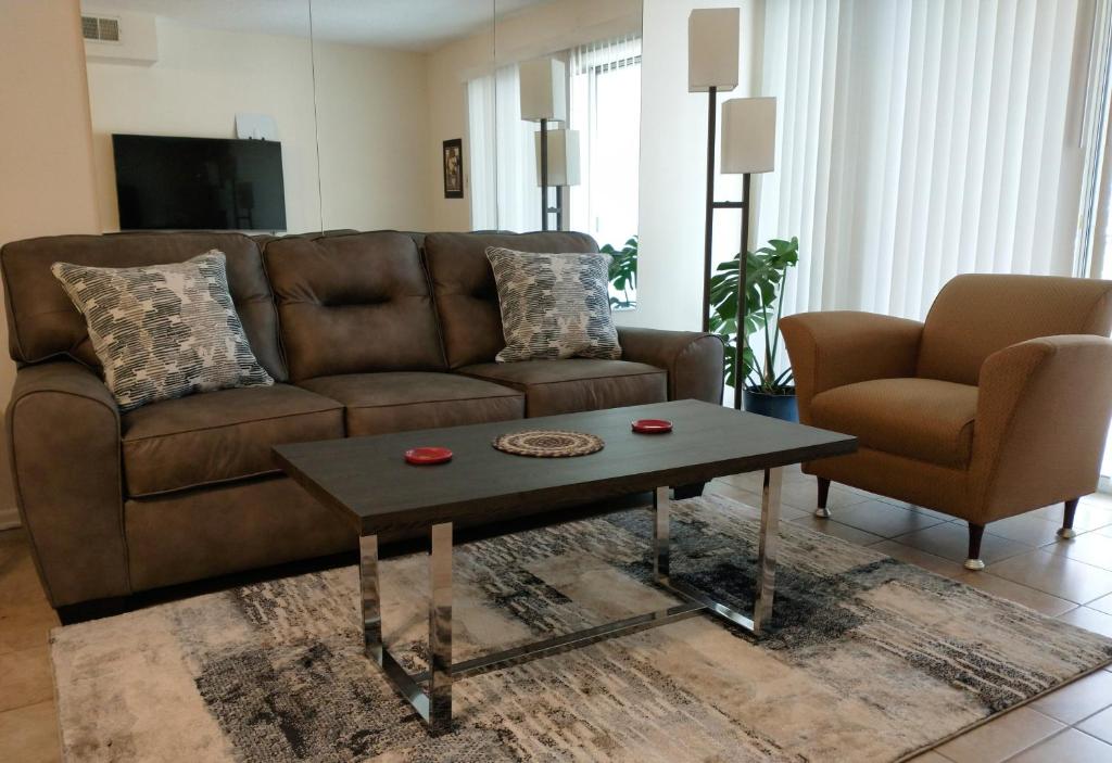 Welcome to Midtown Condo في ليتل روك: غرفة معيشة مع أريكة بنية وطاولة قهوة