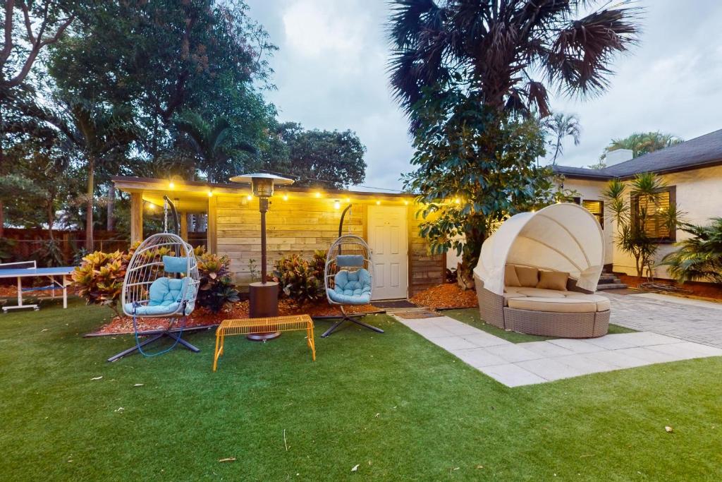 un patio trasero con 2 sillas y una casa en Walking On Sunshine - Studio en Fort Lauderdale