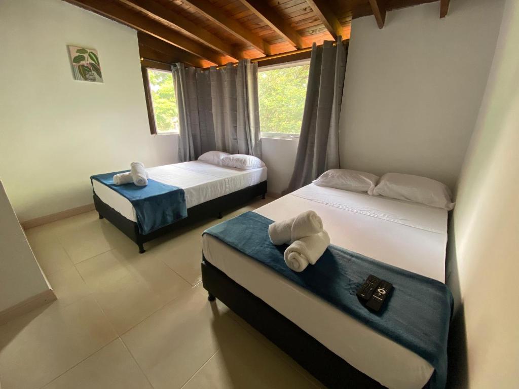 a bedroom with two beds and a window at APARTAHOTEL ESTADIO GOLD in Medellín