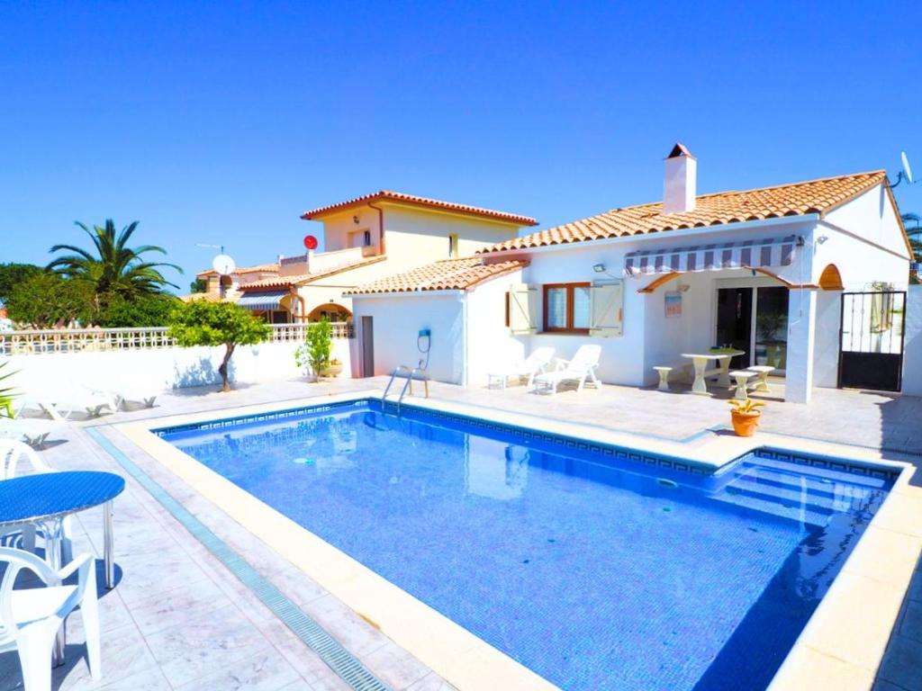 uma villa com piscina em frente a uma casa em Casa L'Escala, 3 dormitorios, 7 personas - ES-325-15 em Torroella de Montgrí
