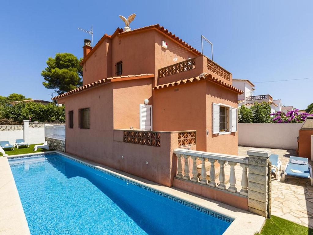a villa with a swimming pool in front of a house at Casa L'Escala, 4 dormitorios, 8 personas - ES-325-12 in Torroella de Montgrí