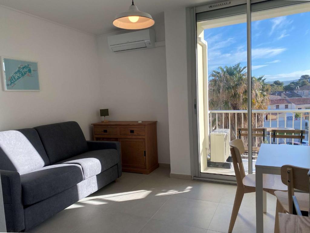 un salon avec un canapé et une table dans l'établissement Studio rénové près des Thermes avec balcon et climatisation - FR-1-553-252, à Balaruc-les-Bains