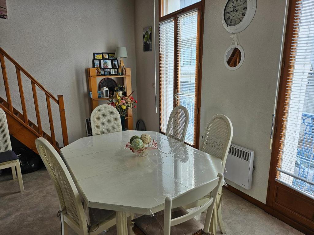 een eettafel met stoelen en een witte tafel bij Appartement Arcachon, 3 pièces, 6 personnes - FR-1-319-543 in Arcachon