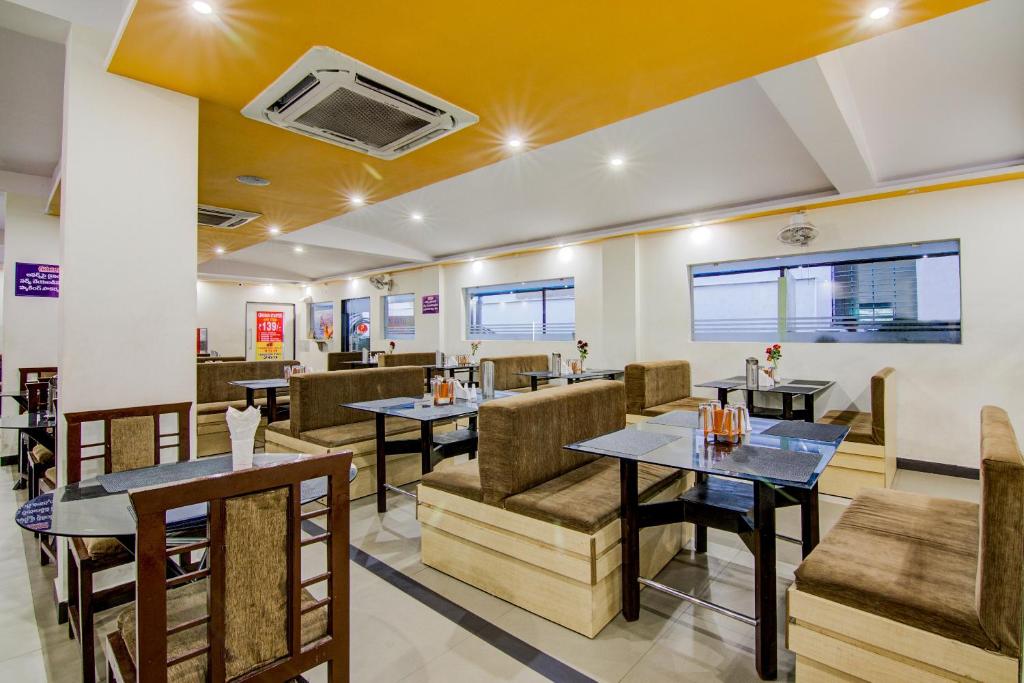 ein Restaurant mit Tischen und Stühlen in einem Zimmer in der Unterkunft Hotel Spar Grand in Visakhapatnam