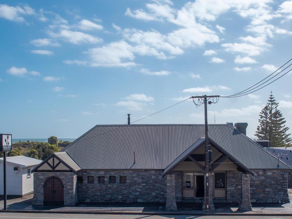 an old brick building with a metal roof at Paroa Hotel in Greymouth
