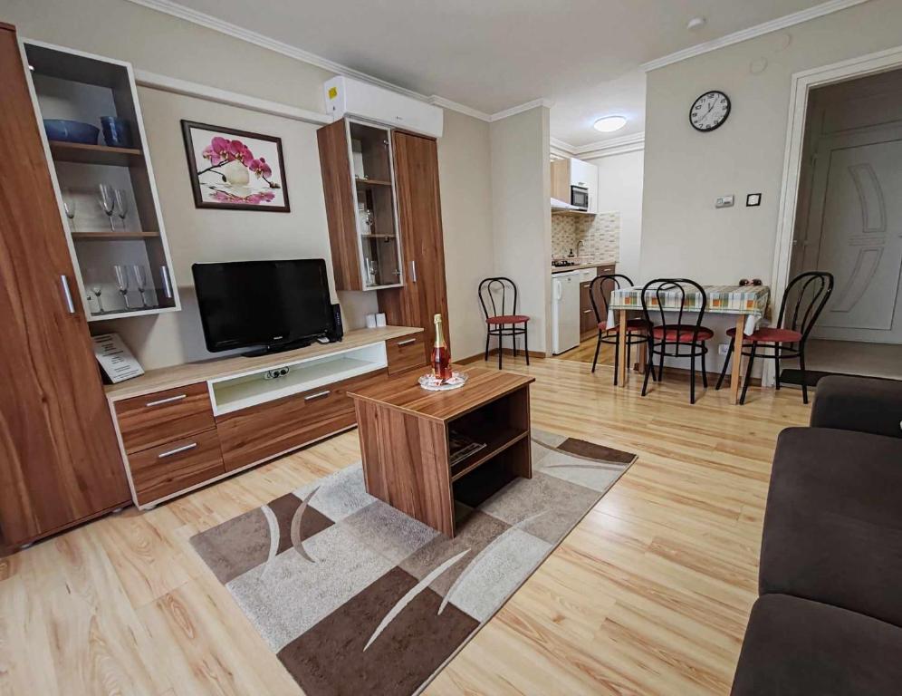 een woonkamer met een televisie en een eetkamer bij Tó Apartman Gunarasfürdő in Dombóvár