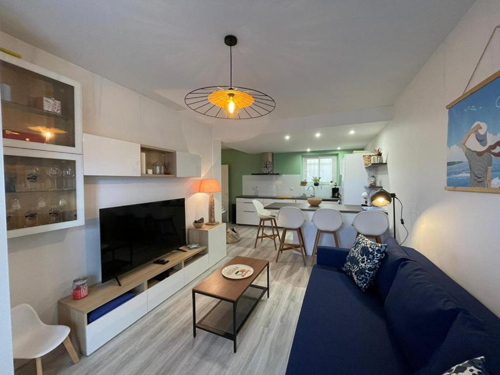 un salon avec un canapé bleu et une table dans l'établissement Charmant appart rénové, 4 pers, 50m plage, WiFi, cour/terrasse, Capbreton - FR-1-413-239, à Capbreton