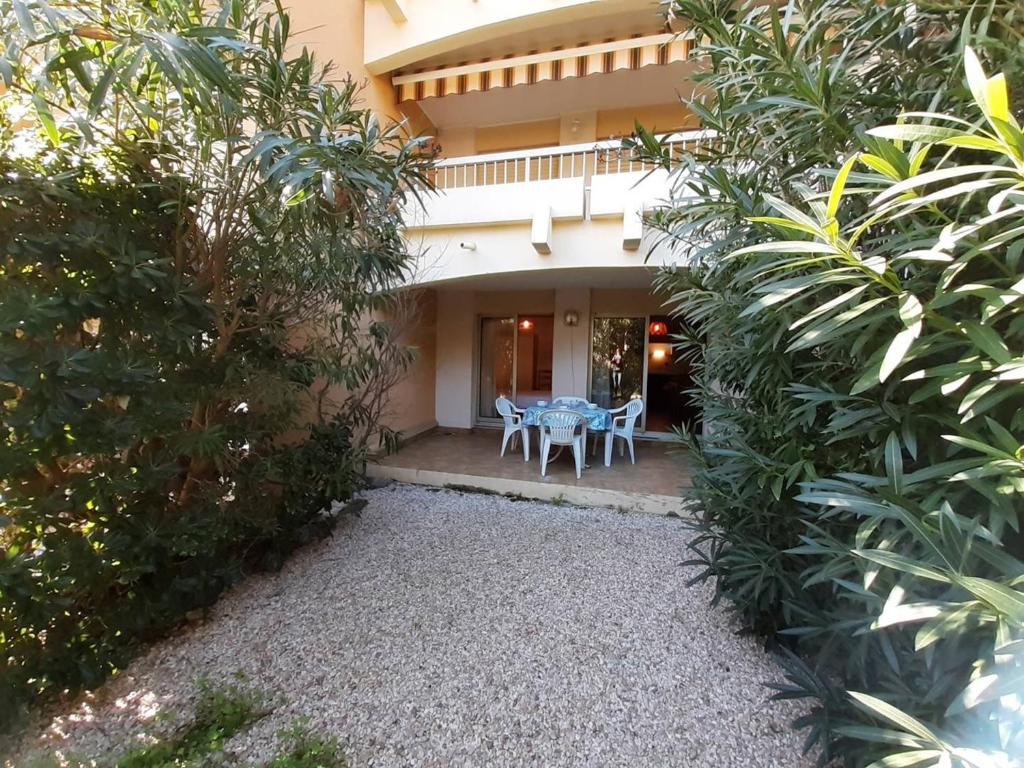 une maison avec une table et des chaises devant dans l'établissement Appartement avec Terrasse et Garage, 250m Plage - Bormes-les-Mimosas - FR-1-251-719, à Bormes-les-Mimosas