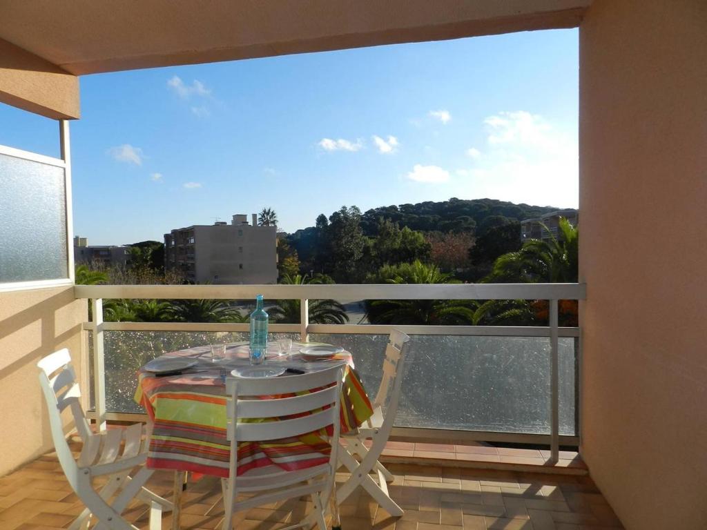 een tafel en stoelen op een balkon met uitzicht bij Appartement Bormes-les-Mimosas, 1 pièce, 3 personnes - FR-1-251-702 in Bormes-les-Mimosas