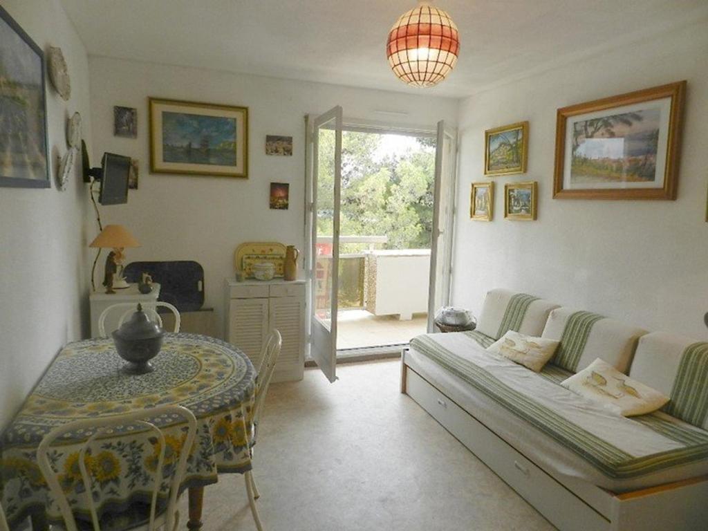 een woonkamer met een bank en een tafel bij Appartement Bormes-les-Mimosas, 2 pièces, 4 personnes - FR-1-251-713 in Bormes-les-Mimosas