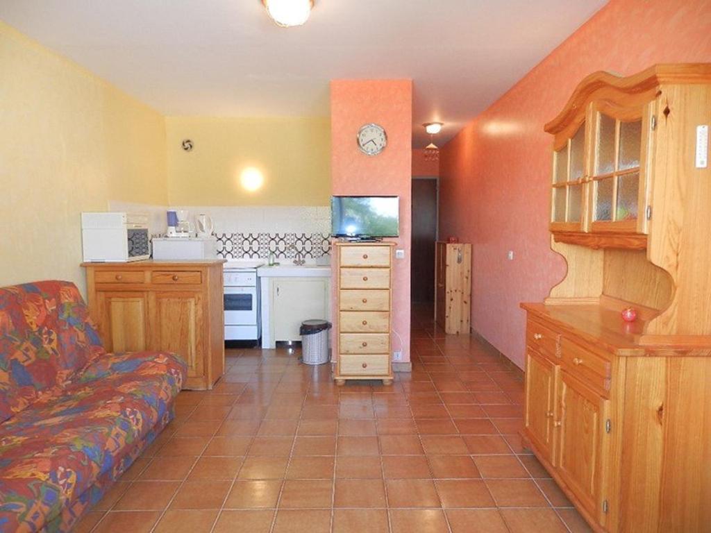 un salon avec un canapé et une cuisine dans l'établissement Studio 3 Couchages à 2 min de la Plage - Bormes-les-Mimosas, Parking Inclus - FR-1-251-720, à Bormes-les-Mimosas