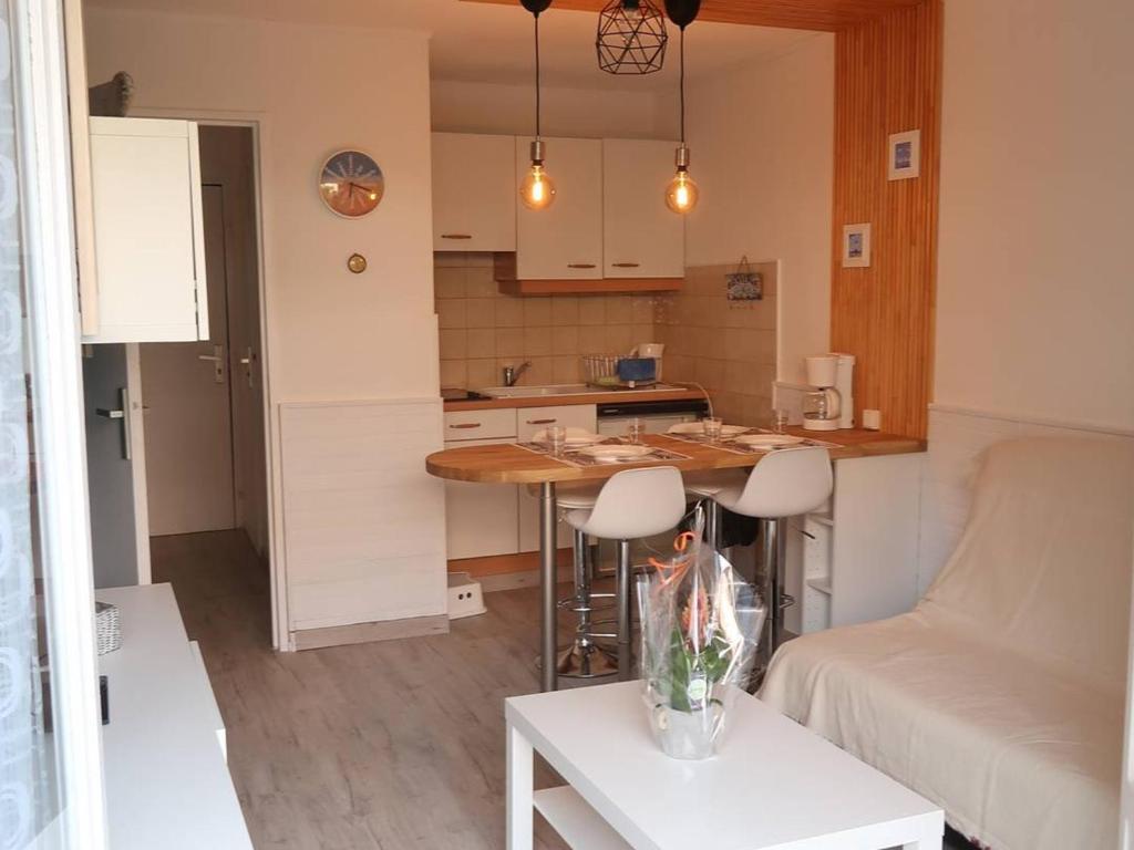 uma cozinha e uma sala de estar com uma mesa e um sofá em Appartement Bormes-les-Mimosas, 2 pièces, 4 personnes - FR-1-251-735 em Bormes-les-Mimosas