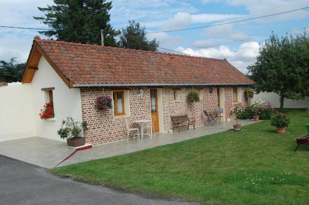 a small white brick house with a yard at Au Clos du Logis in Maintenay