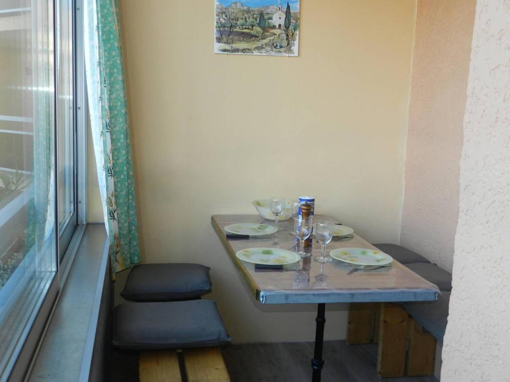- une petite table avec des assiettes et des verres à vin dans l'établissement Appartement 4 couchages à 350m de la plage avec garage privatif à Bormes-les-Mimosas - FR-1-251-725, à Bormes-les-Mimosas