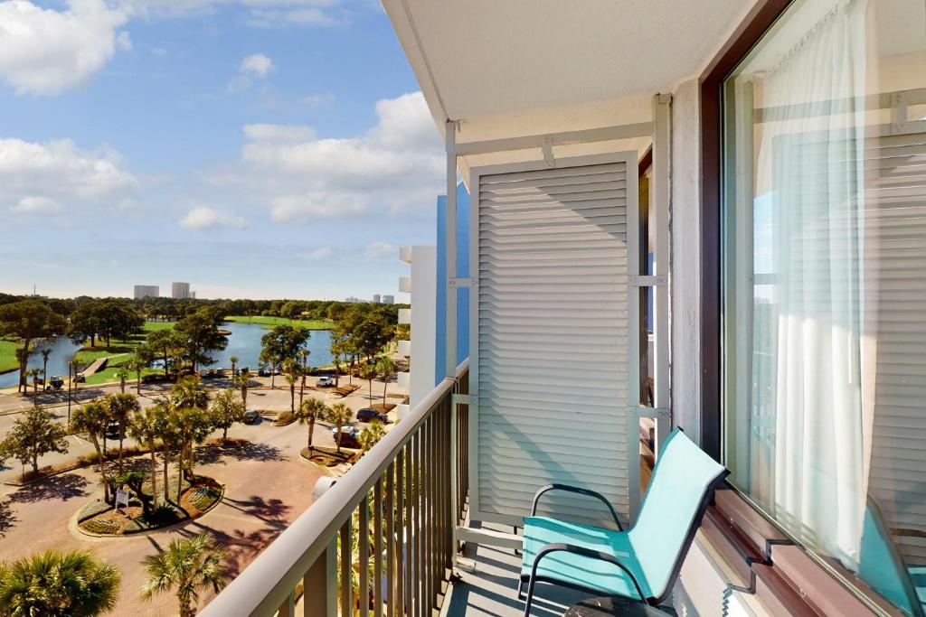 a balcony with a blue chair and a view of the resort at Bayside at Sandestin #6769 in Destin