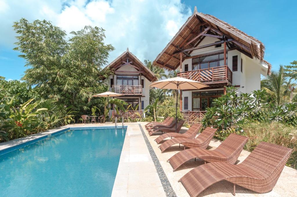 una villa con piscina di fronte a una casa di Bulan Villas Siargao a General Luna