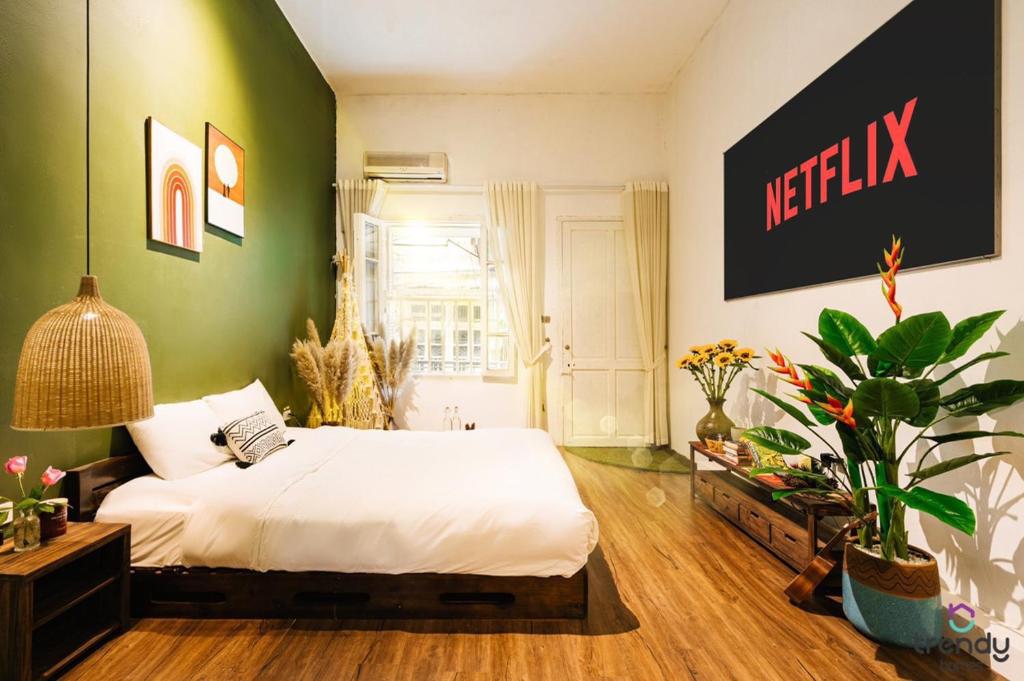 - une chambre avec un lit blanc et un mur vert dans l'établissement OH Trendy APARTMENT TT, à Hanoï