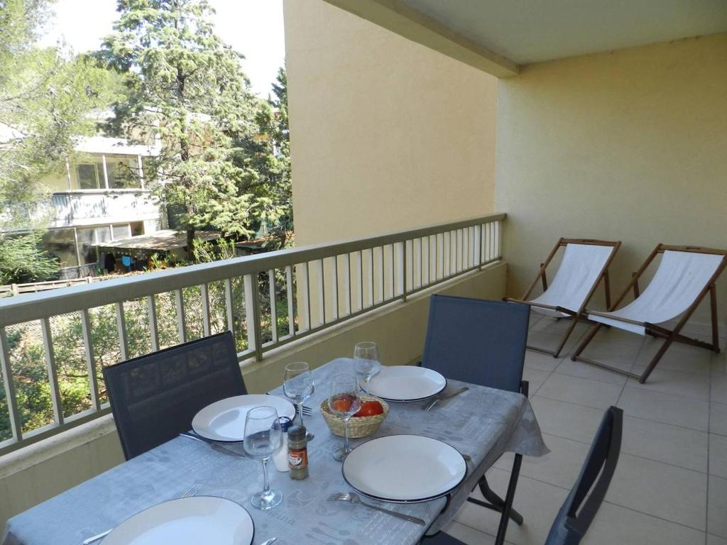 une table et des chaises sur un balcon avec une table et des chaises dans l'établissement Appartement Moderne avec Terrasse, Parking et Proximité Plage à Bormes les Mimosas - FR-1-251-745, à Bormes-les-Mimosas