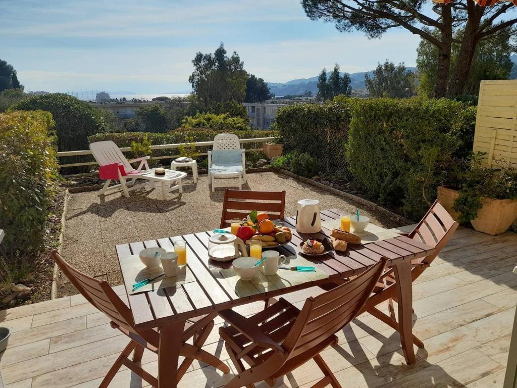 une table en bois avec une assiette de nourriture dessus dans l'établissement Location T2 climatisé, proche plage, parking privatif à Bormes-les-Mimosas - FR-1-251-747, à Bormes-les-Mimosas