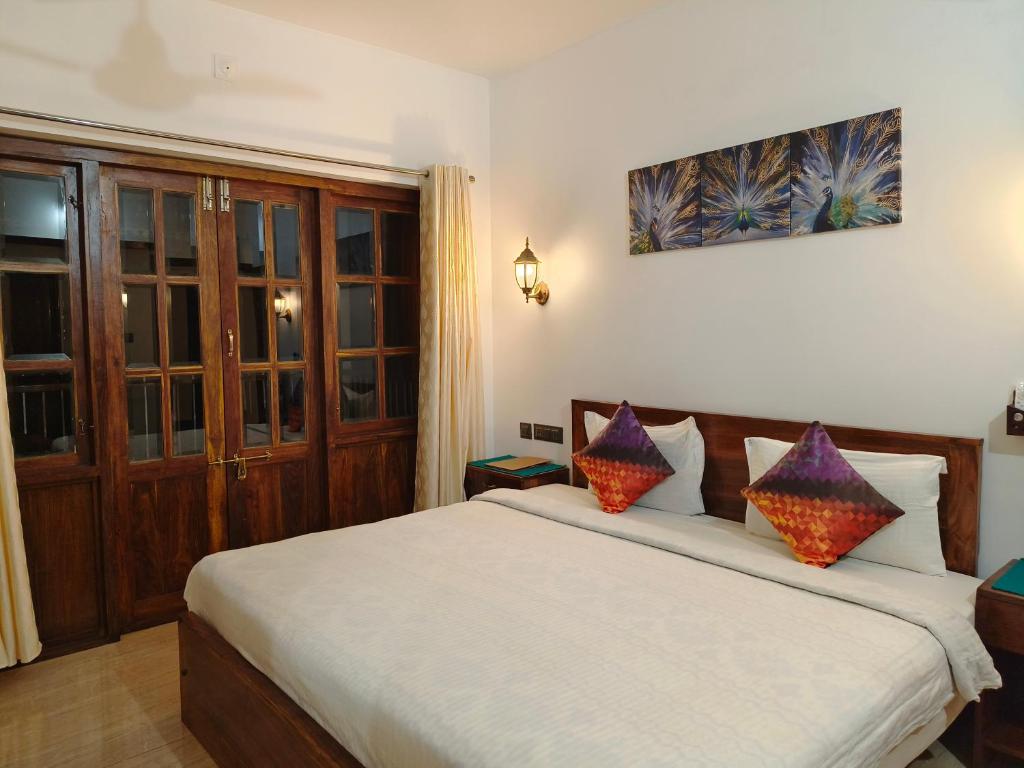 a bedroom with a large bed with two pillows at Ananda Holiday Home in Ambalavayal