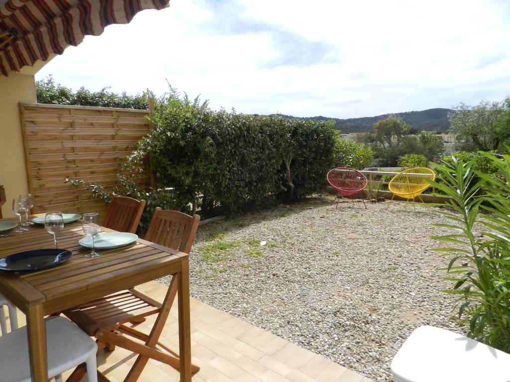d'une terrasse avec une table et des chaises dans l'arrière-cour. dans l'établissement Appartement 2 pièces avec Jardin, à 250m de la Plage - Bormes-les-Mimosas - FR-1-251-768, à Bormes-les-Mimosas