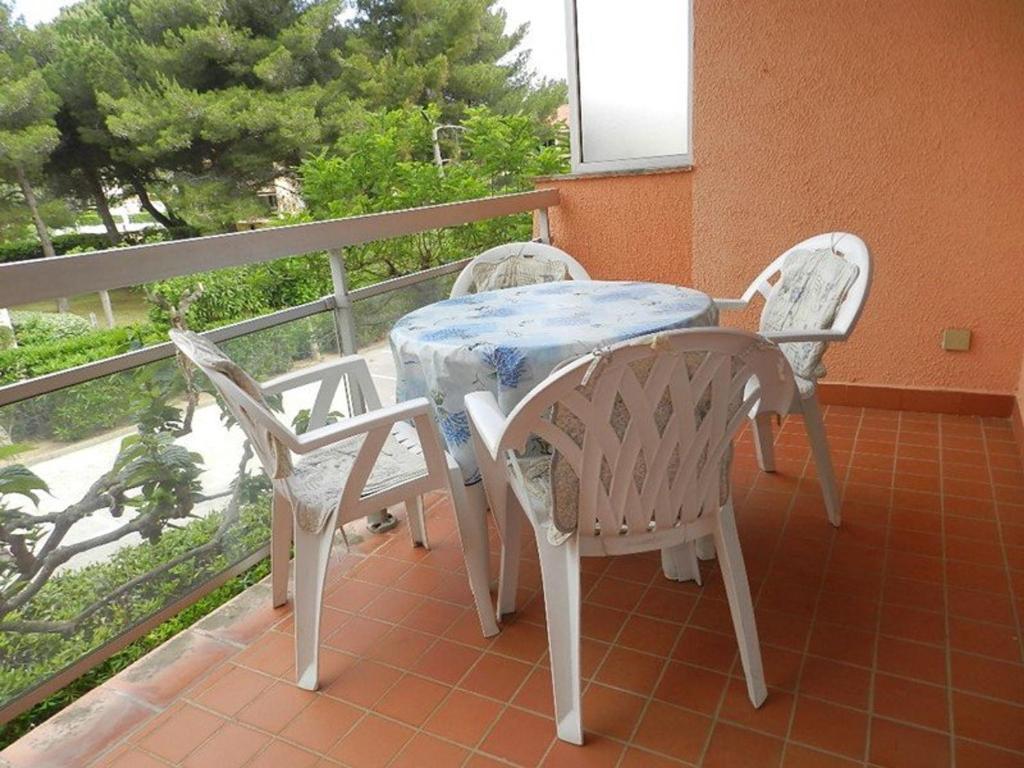 une table et deux chaises assises sur un balcon dans l'établissement Appartement T2 proche plage et commerces, 4 couchages, Bormes-les-Mimosas - FR-1-251-765, à Bormes-les-Mimosas