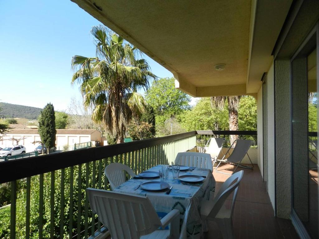 une table et des chaises sur un balcon avec vue dans l'établissement Charmant T2 avec terrasse et parking au calme, Le Lavandou - FR-1-251-766, au Lavandou