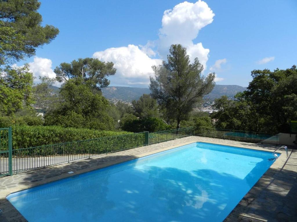 - une piscine bleue avec vue sur les montagnes dans l'établissement Appartement 3 pièces avec piscine, parking et animaux admis - FR-1-251-757, au Lavandou
