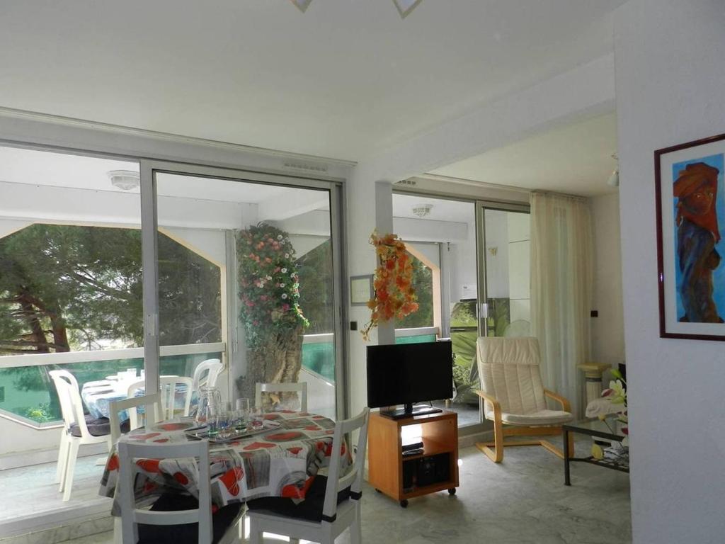 ein Wohnzimmer mit einem TV, einem Tisch und Stühlen in der Unterkunft Appartement Bormes-les-Mimosas, 3 pièces, 6 personnes - FR-1-251-771 in Bormes-les-Mimosas
