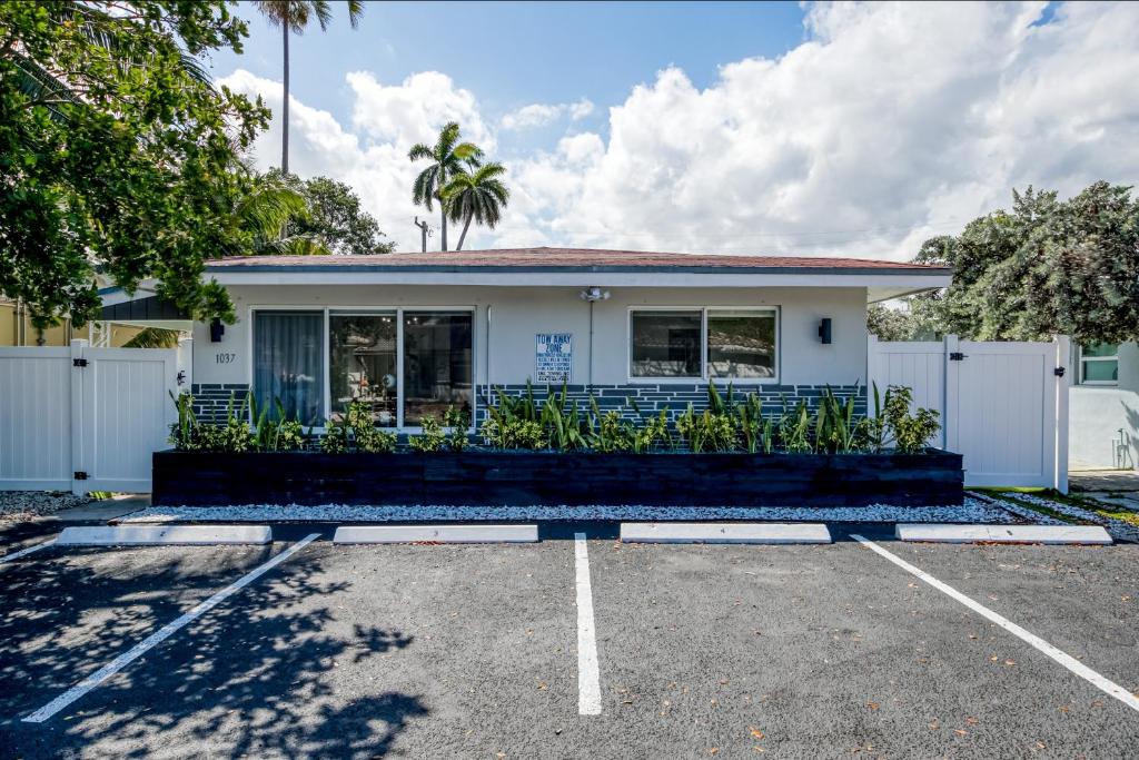 una casa blanca con una valla en un estacionamiento en Sunflower Skies #1, en Fort Lauderdale