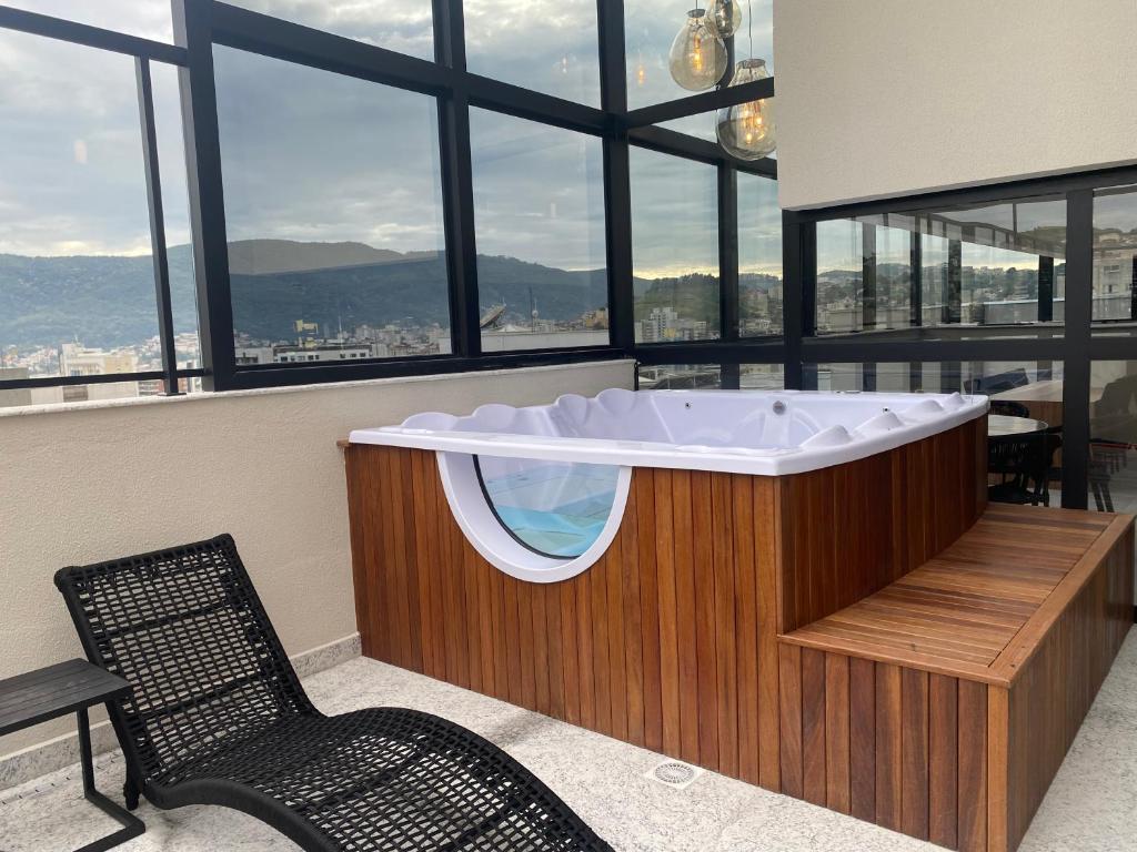 a bath tub in a room with a window at Studio aconchegante in Poços de Caldas