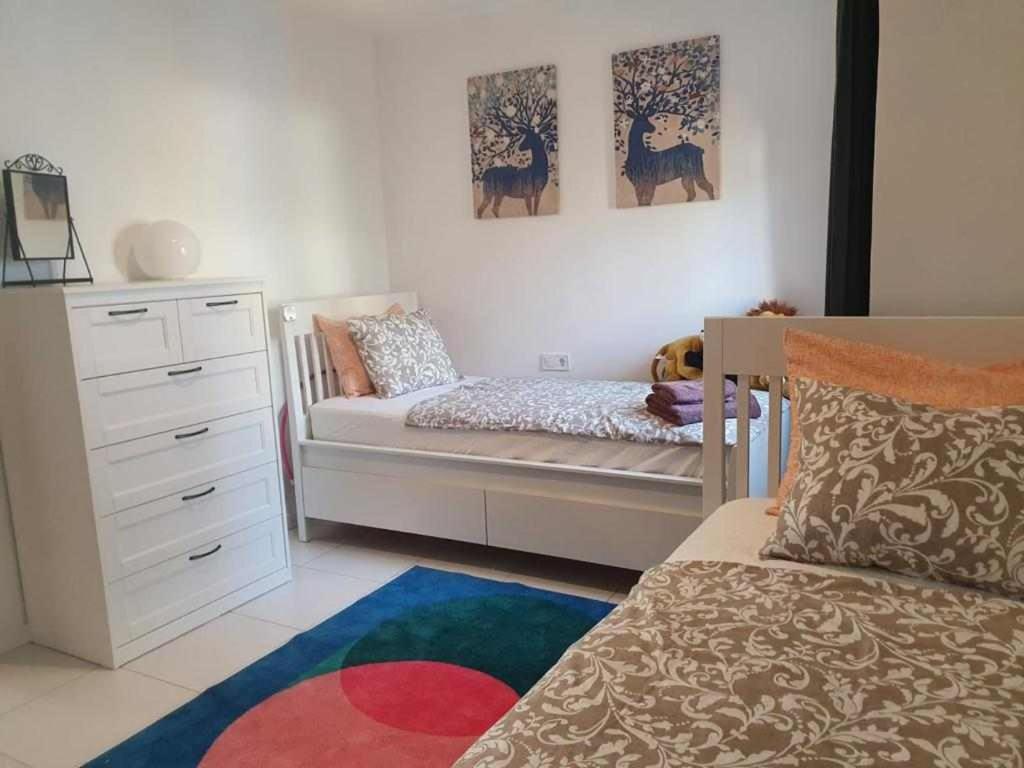 ein Kinderschlafzimmer mit einem Kinderbett und einem Bett in der Unterkunft Casa Verde in Cales de Mallorca