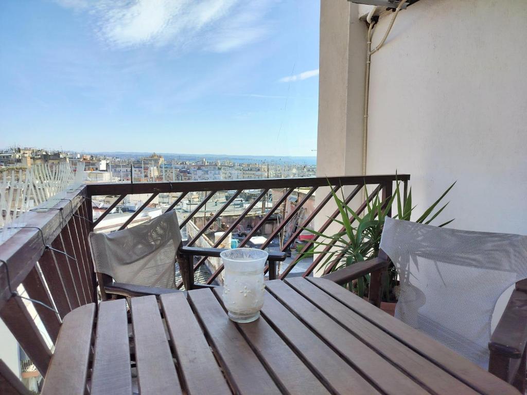 a wooden table on a balcony with a drink on it at Castle View Thessaloniki in Thessaloniki